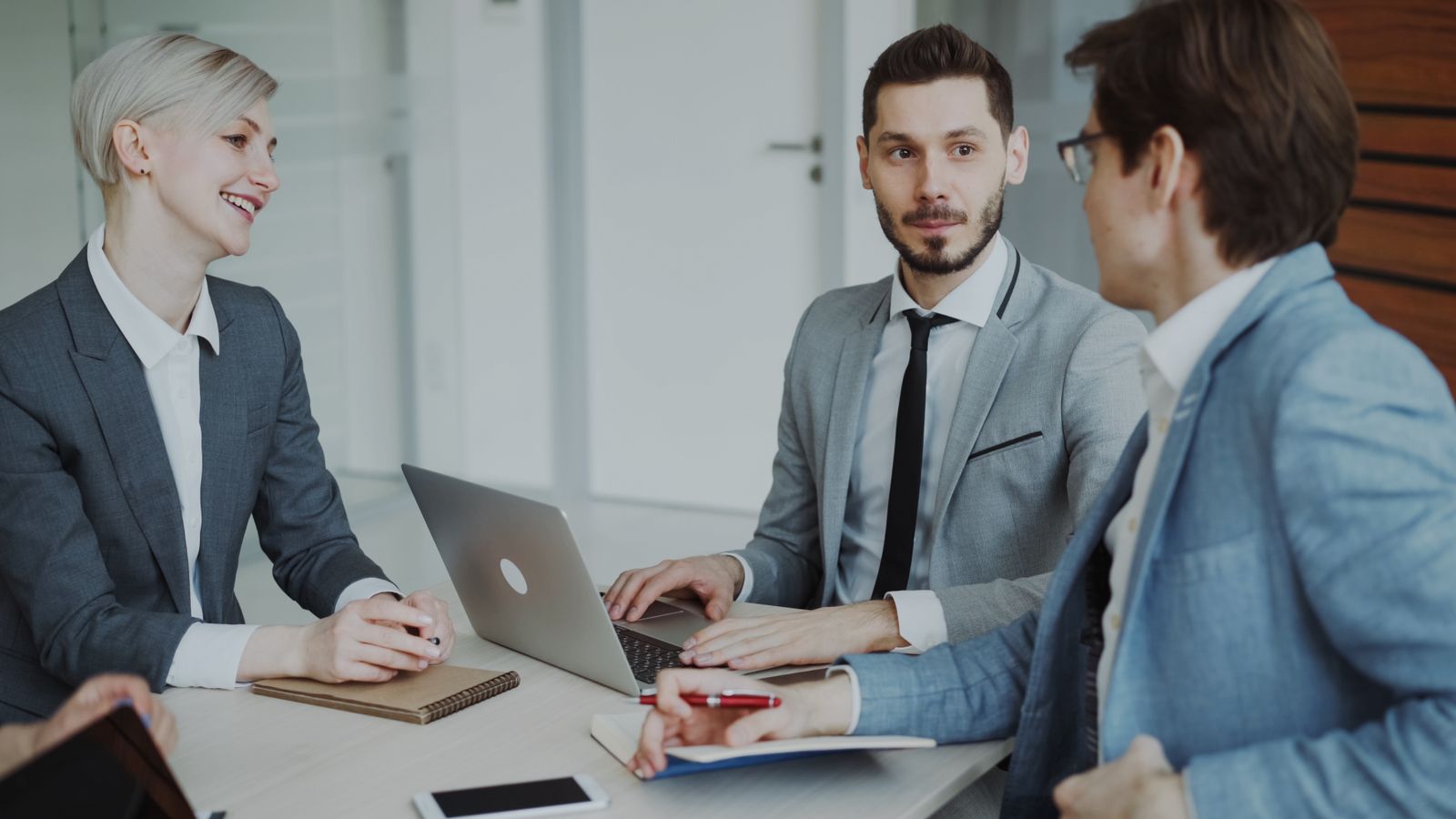 Equipo de trabajo reunido en torno a un computador